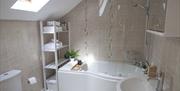 The bathroom has a built in jacuzzi style spa bath, electric shower, towel radiator, electric shaving point and skylight.