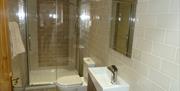 Image shows bathroom with toilet, shower and sink