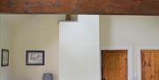 Image shows the living room of the Bothy. This is a wide shot that includes the feature roof trusses.