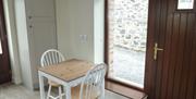 Image shows the dining area with two chairs and table.