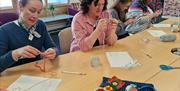 4 women learning to crochet at Midtown Makers workshop