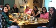 A group enjoying fresh baked goods and tea around the table