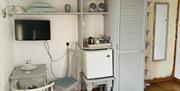 Interior of Room with A View showing wardrobe, fridge, small dining area & locked doorway between the Room with a View annex and main house.