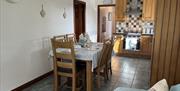 Tiled kitchen with dining table for six and a hob/oven.