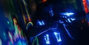 A child aiming her laser blaster in the laser tag arena.