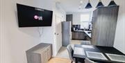 Open plan dining area/kitchen with a tv.