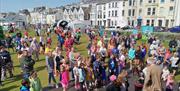 crowds of families are gathered on Kerr Street Green in Portrush