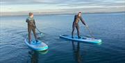 Two men standing up on paddleboards