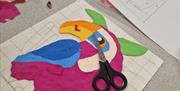 textured art of a pink parrot in progress at Midtown Makers workshop.