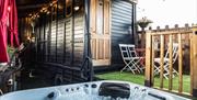 Image shows hot tub with patio and entrance to horse truck with door closed