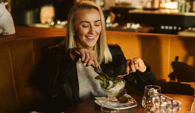 Guest enjoying their festive lunch at Castle Kitchen & Bar surrounded by festive decor and cosy lighting
