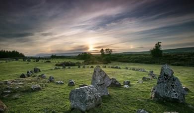 Image of the Beaghmore stone circle with the sun setting in the distance