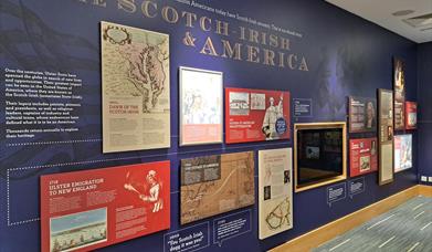 Informative exhibit wall showcasing the history of the Ulster-Scots/Scotch-Irish in America. The information features maps, text panels, and images of