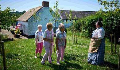 Group of people walking through garden at Arthur Cottage