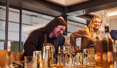 A couple preparing cocktails at McConnell's Distillery.