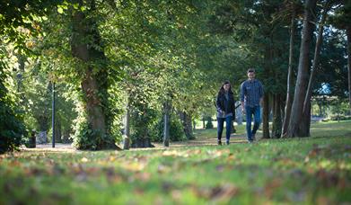 Image shows a woman and man walking in Wallace Park