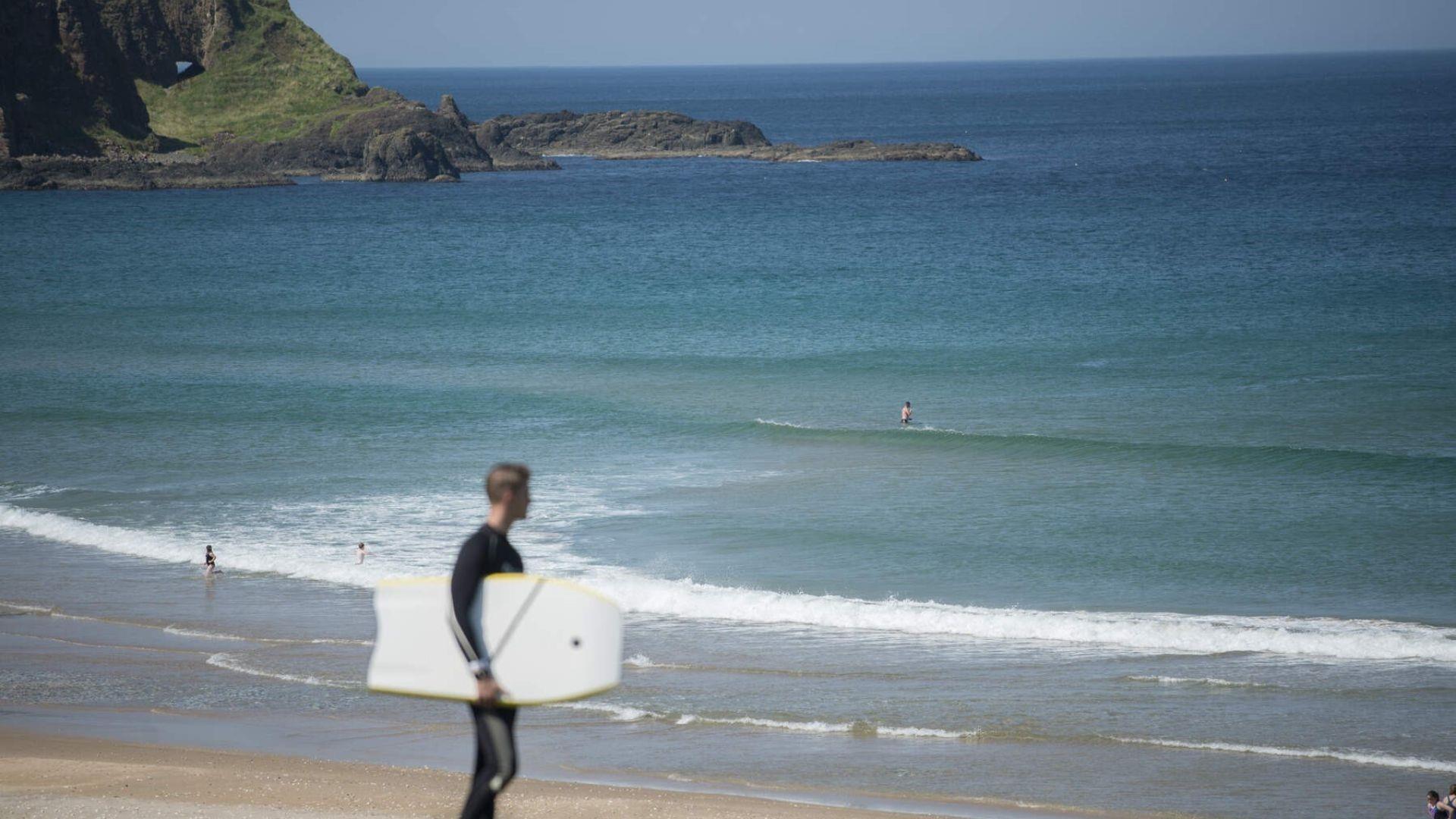 An image of the water at Whiterocks Beach with a surfer in the foreground