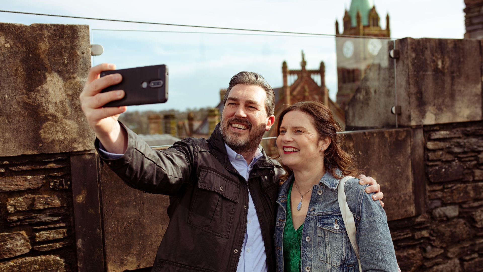 Couple taking a selfie outside the Tower Museum in Derry~Londonderry