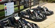Image is of a few go-karts lined up on the ground