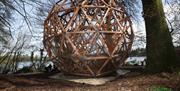 An image of the Magic Garden Sphere set beside the lake and forms part of the digital sculpture trail.