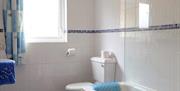 Tiled bathroom with bath, sink and toilet