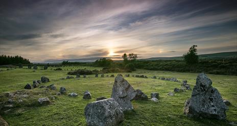 Image of the Beaghmore stone circle with the sun setting in the distance