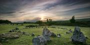 Image of the Beaghmore stone circle with the sun setting in the distance