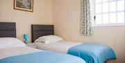 Two single beds with blue and white linen