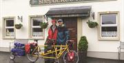 couple with tandem bicycle outside front door of Shepherd's Rest bar