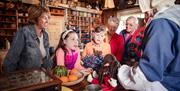 Family interact with staff at an old fashioned shop