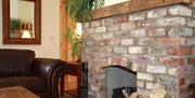 Image shows brick fireplace with open fire and logs