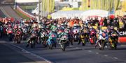 a large number of motorcyclists taking off from the starting line at the North West 200