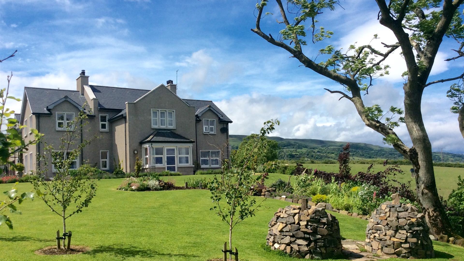 View of BallyCairn House from front garden. Situated on an elevated, picturesque location overlooking the Irish Sea with backdrop views of the Antrim