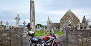 Image shows motorcycle parked outside churchyard gates