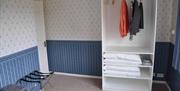 Walls with patterned wallpaper and a open wardrobe