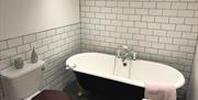 An image of the bathroom with free standing bath and modern tiled bathroom