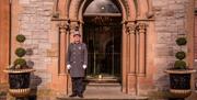 Photo of Doorman standing at the ornate front entrance to the hotel
