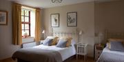 Spacious Triple bedroom with grey and yellow colour scheme
