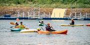 Image shows people kayaking in a lake