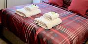Image of a double bed with towels and toiletries on top