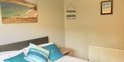 double bedroom with bedside locker and white and blue linen