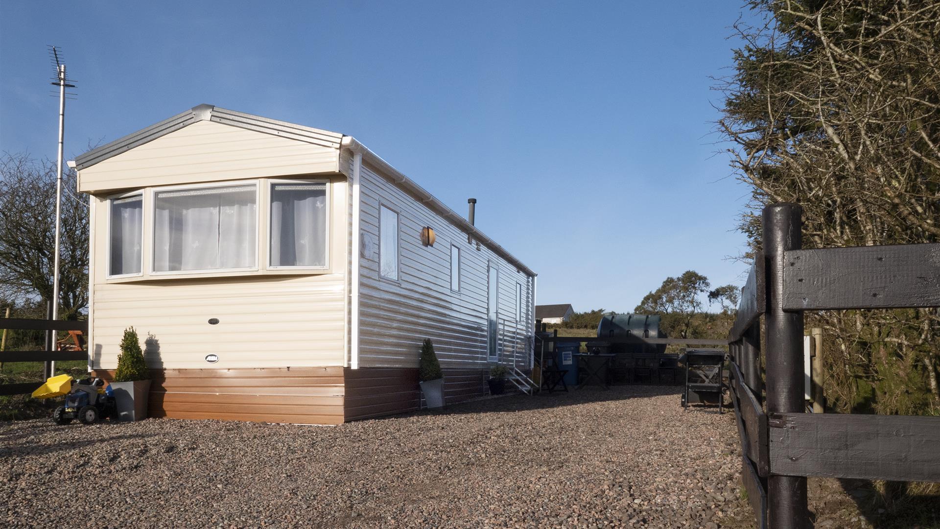 Image of the exterior of a static caravan and a stoned driveway