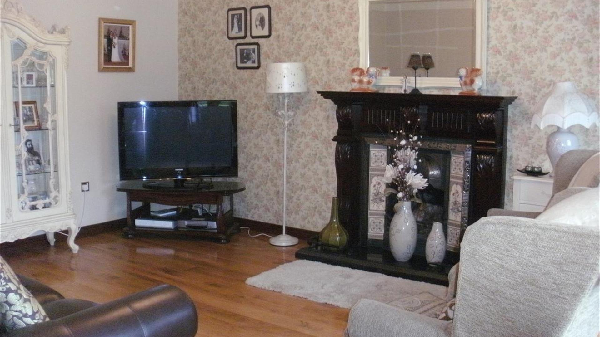 living area with TV, fireplace, sofa and armchairs