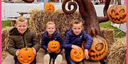 Kids posing for a photo with their carved Hallowe'en pumpkins