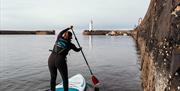 A stand up paddleboarder in Donaghadee Harbour