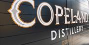 A close up side view photo of the Copeland Distillery venue sign