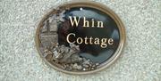a photo of a sign saying whin cottage