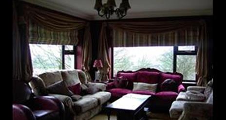 Image shows lounge with sofas and coffee table