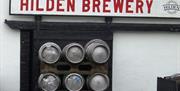 Image is of the Hilden Brewery sign on the outside wall with beer barrels underneath