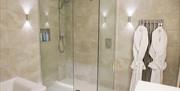 Shows image of walk in shower and hanging bath robes